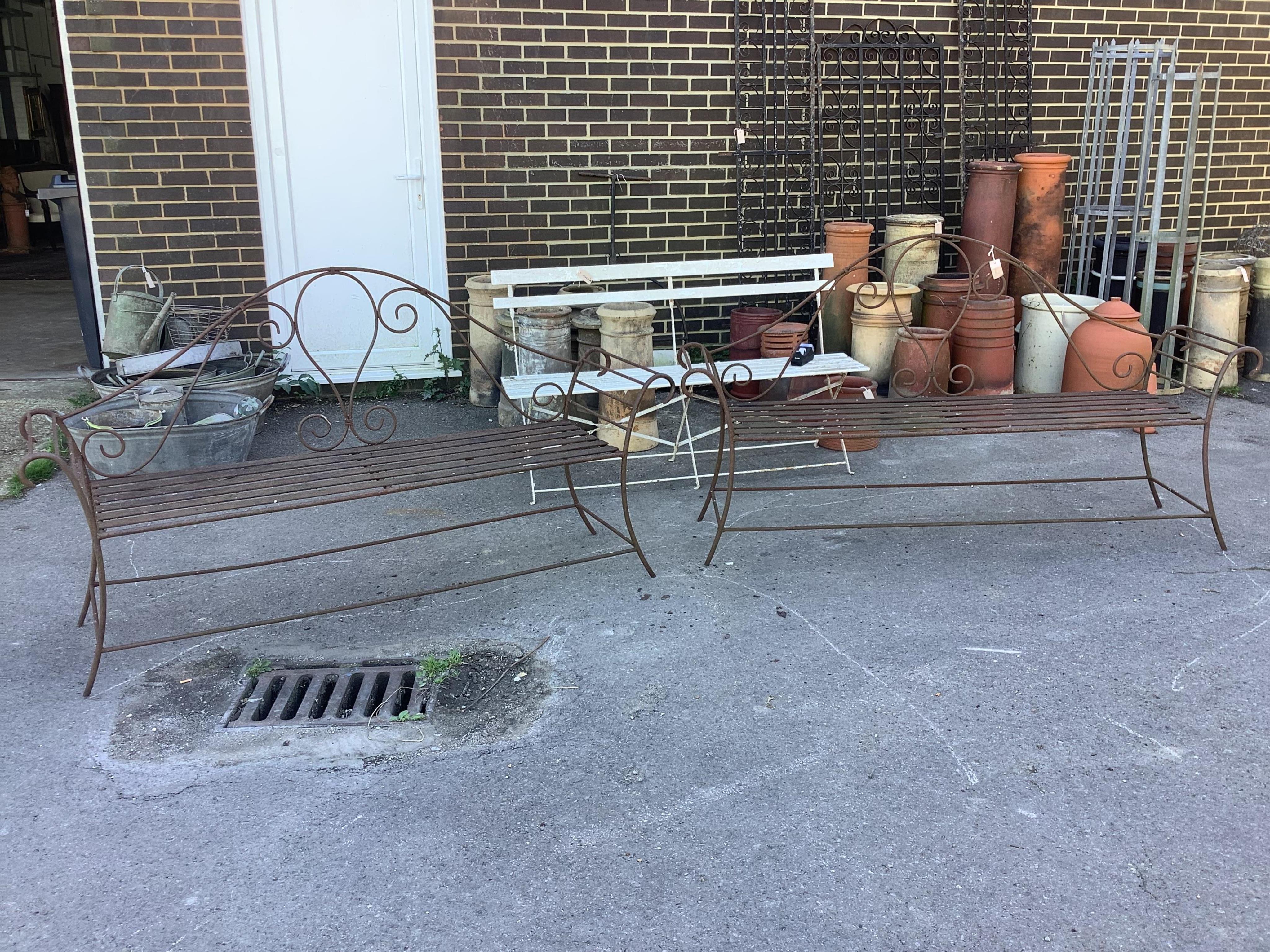 A pair of wrought iron garden benches, width 184cm, height 102cm. Condition - fair